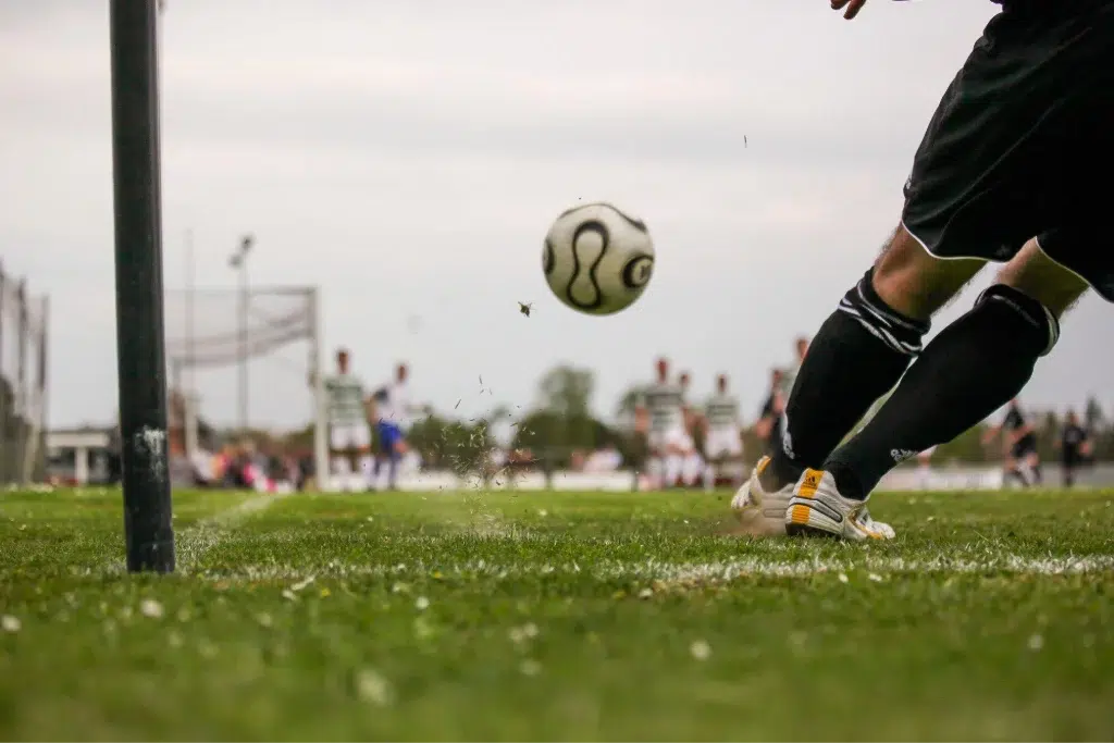 lower body of the a soccer player getting ready to catch the football on a field