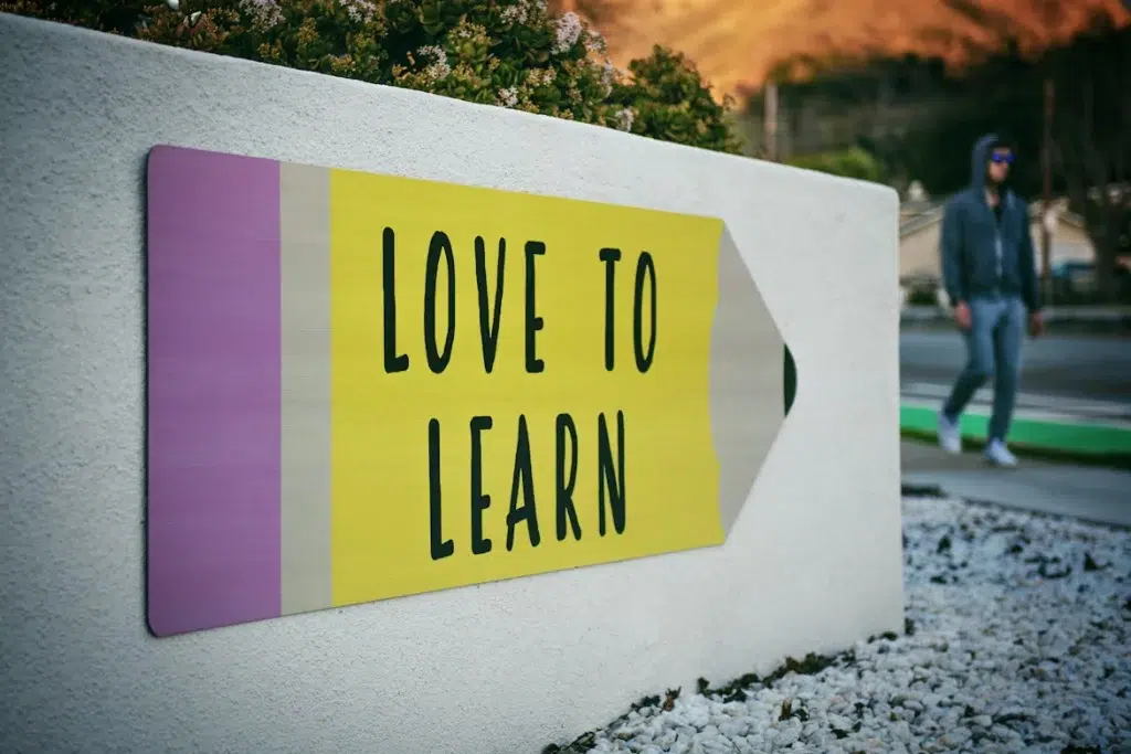 a huge pencil-like sign with text "love to learn" decorates teh wall