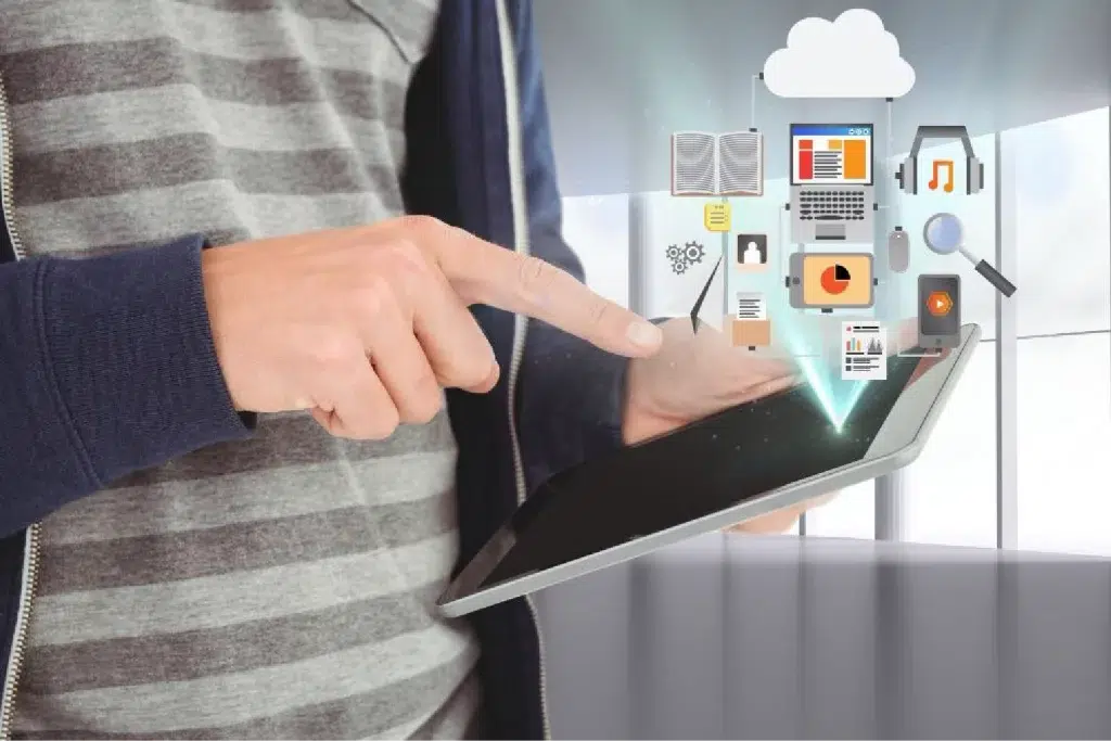 photo depicts a person holding a tablet in their hands with vector icons hovering over the laptop screen