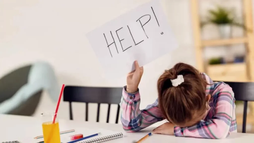 a young girl is laying on the table hold a "help" sign