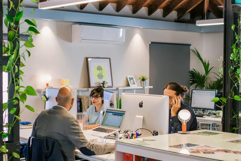 a small group of people working on their computers in the creative office setting
